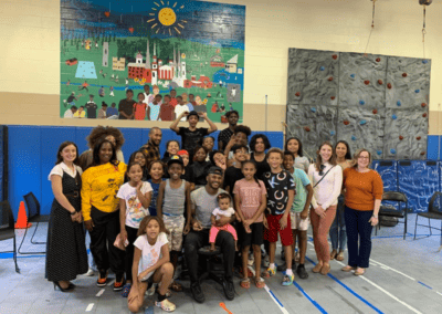 Young kids and adult supervisors in front of mural for group photo